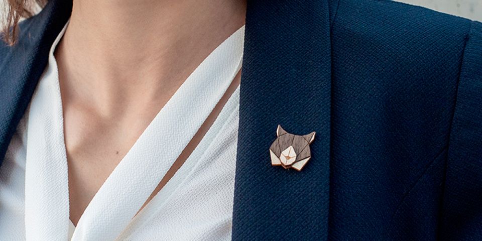 A woman in a jacket with the wooden brooch Lynx Brooch