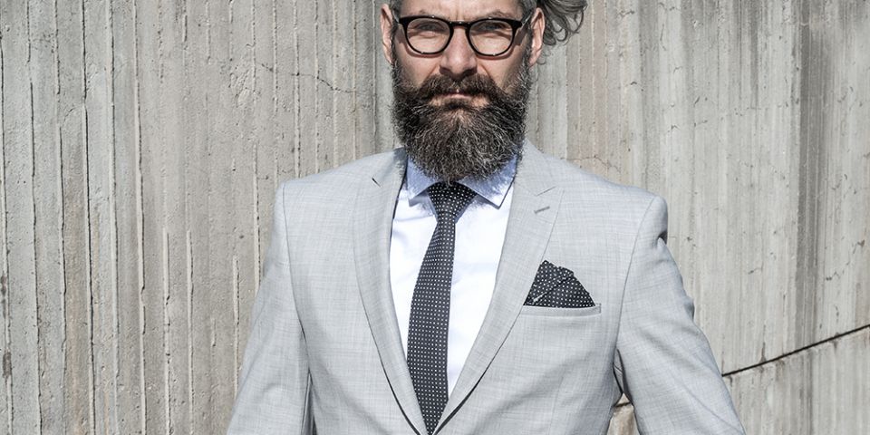 Man in a gray jacket with Coloo pocket square and Coloo Tie Man in a gray jacket with Coloo pocket square and Coloo Tie